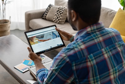 穿蓝白红格子衬衫的男人在用macbook pro